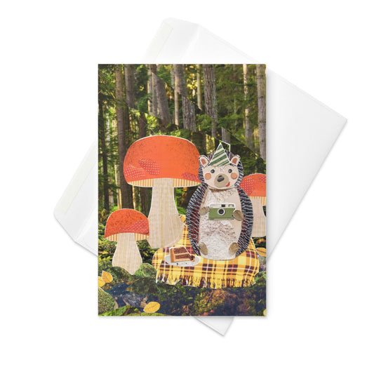 collage art greeting card with a hedgehog in party hat holding a camera in a forest setting featuring mushrooms and trees.